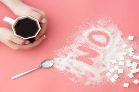 Foto palavra não feita de açúcar e xícara de café em fundo rosa plano