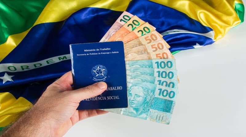 Foto de mão segurando documento brasileiro de trabalho e previdência social carteira de trabalho e previdência social com brasileiro
