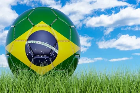 Foto bola de futebol com bandeira brasileira na grama verde contra o céu azul renderização em 3d