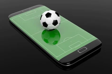 Foto de campo de futebol com bola na tela de borda do smartphone isolada em preto