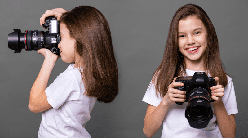 Photo cute brunette little girls holding an photo camera isolated on gray background