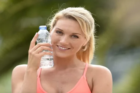 Garota fitness bebendo água depois de se exercitar