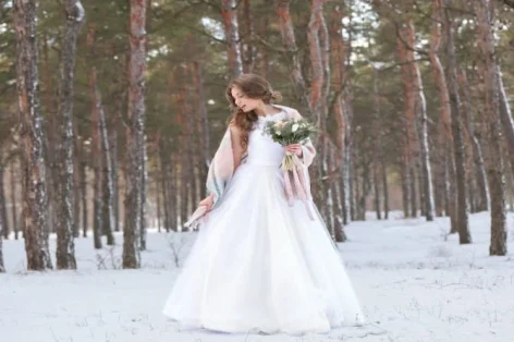 Foto linda noiva com buquê ao ar livre em dia de inverno