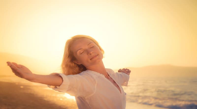 Foto mulher feliz contra o pôr do sol com fundo do mar