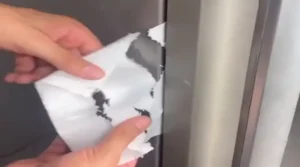 Imagem do papel toalha sendo retirado da porta da geladeira