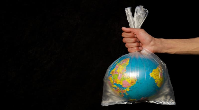 Foto terra embrulhada em saco plástico. globo em um saco plástico. conceito de poluição plástica da terra.
