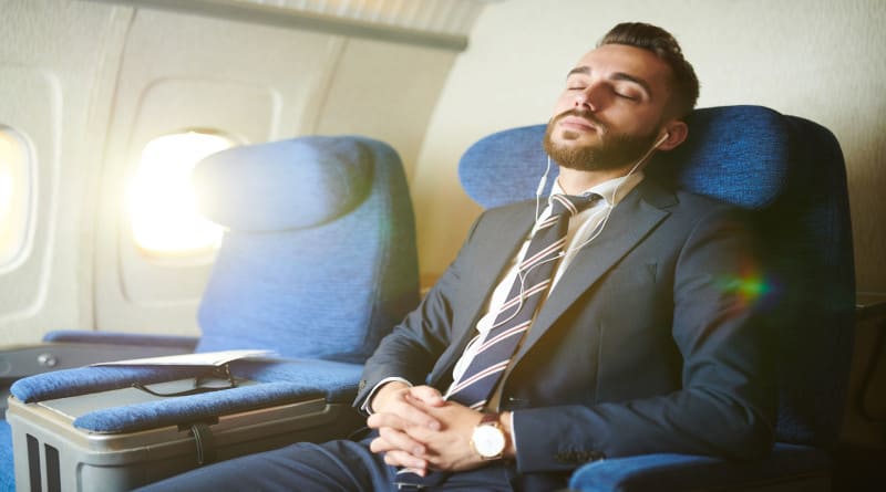 Foto empresário bonito dormindo no avião