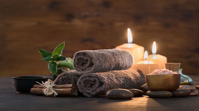 Foto toalhas marrons com bambu e velas para massagem relaxante spa