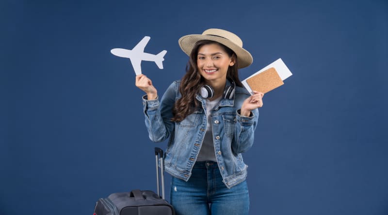Foto feliz jovem asiática segurando passaporte com cartão de embarque e maquete de avião