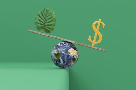 Nature and dollar on a wooden board balancing on a planet Earth
