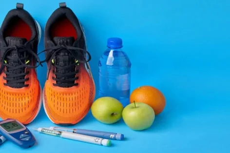 Foto tênis laranja frutas glicosímetro canetas seringa de insulina e garrafa de água potável de plástico em um fundo azul